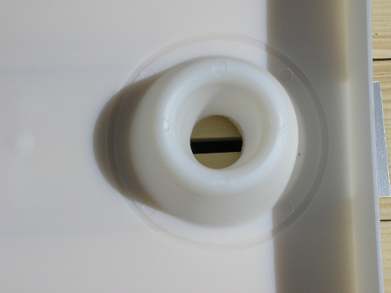 Le nourrisseur, un bac en plastique posé sur la planche couvre-cadre, un trou permet aux abeilles de passer du corps au nourrisseur